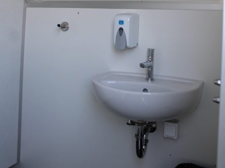 Weißes WC in einem modernen, minimalistischen Badezimmer.